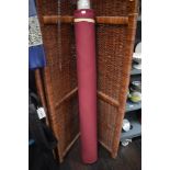 A roll of haberdashery or upholsterers fabric in burgundy