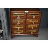 A late Victorian shop counter apothecary or similar storage chest in mahogany with glass handles and