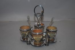 A Doulton Lambeth egg cup and spoon set with silver plated holder