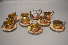 A miniature ceramic dolls house tea service with hand decorated and signed fruit pattern