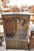 A traditional dark stained Priory style display cabinet with leaded glass doors