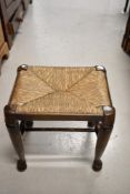 A traditional rush seated stool having double H stretcher