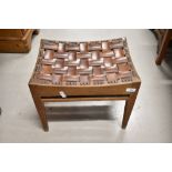 An Arts and Crafts oak and leather stool in the Simpson Handicrafts or Stanley Webb Davies style