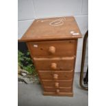 A narrow pine chest of five drawers