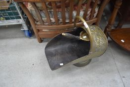 A traditional brass coal helmet , with shovel