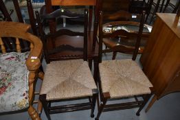 A pair of traditional rush seated ladder back chairs