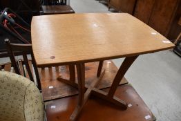 An Arts and Crafts golden oak occasional table having chip carved detailing to four shaped legs on