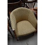 A traditional upholstered tub chair with turned frame