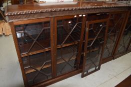 An early 20th Century mahogany single height double with bookcase having astral glazed doors