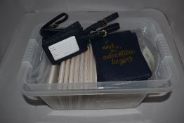 A box of passport holders and luggage ties.