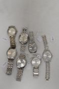 Seven mens watches having silver tone straps.