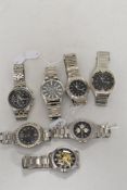 Seven mens silver tone watches, all having dark faces.