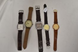Five mens watches having brown straps.