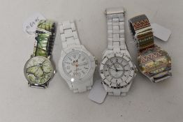 Four mens watches having, all white and two with designs.