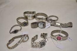 Ten ladies watches having silver tone straps, one having pink face.