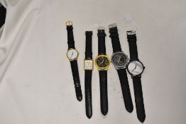 Five mens watches all having black straps.