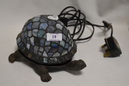 A modern Tortoise design table lamp with cast metal body and leaded light shade