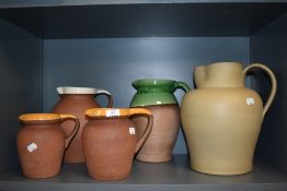 A selection of vintage studio pottery water jugs in terracotta with various glazes