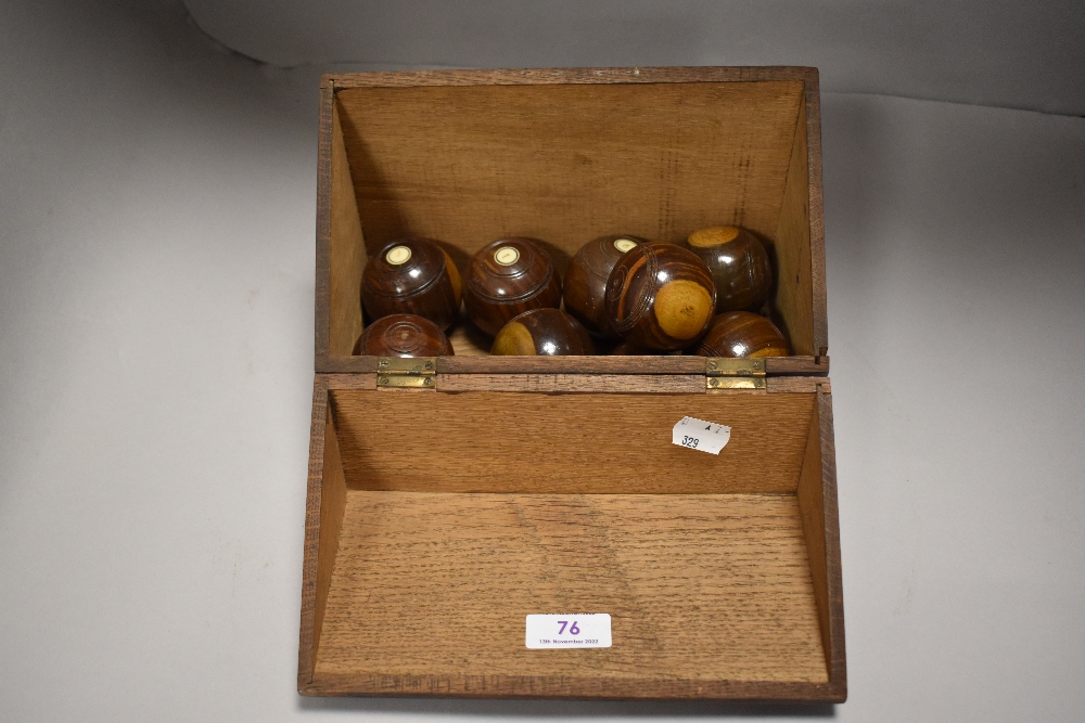 An early 20th century Thomas Royal set on miniature carpet bowls in oak case
