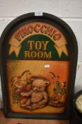 A modern sign being hand painted for Pinocchio Toy Room with a scene of Santa and a clown