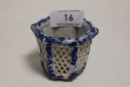 A small Chinese blue and white ware pot having lattice pierced sides on six footed base