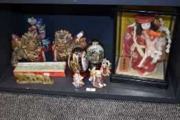 A selection of modern oriental items including decorated eggs, dogs of fo, and a cased Japanese