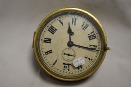 An early 20th century brass cased nautical ships clock, heavy set with bevelled glass and in working