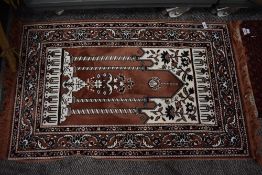 An Oriental fringed rug or prayer mat.