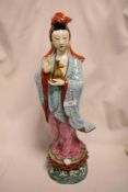 A large Chinese porcelain figure of a lady holding bottle on a sea wave and lotus flower base