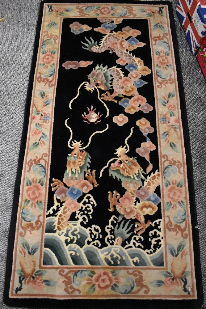A modern Chinese style carpet runner in beige and black ground with a floral and fruit border