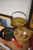 A selection of brass wares including rampant lion trivet, jam pan and sauce pan and a candle