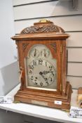 An early 20th century bracket clock having carved oak case with brass details and HM silver