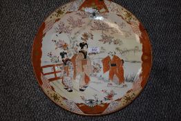 A Meiji Kutani ware pattern charger depicting mother and daughter in discussion with villager