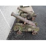 A pair of reproduction cannons on weathered wooden carriages, cannon length 100cm, carriage length