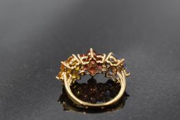 A multi coloured (fancy) sapphire triple daisy cluster ring in shades of yellow, red and pale blue