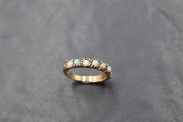 A seven stone opal half eternity ring on a yellow metal loop stamped 9ct, size L & approx 2.3g