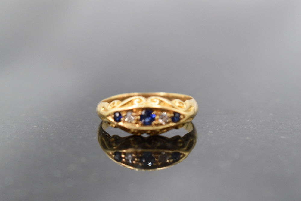 An 18ct gold diamond and sapphire ring, a linear arrangement of five stones within an elliptical