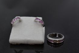 An 18ct white gold band ring having channel set graduated princess cut diamonds and pink