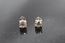 A pair of diamond solitaire stud earrings, each stone approx 1ct in 4 claw white gold mounts, no