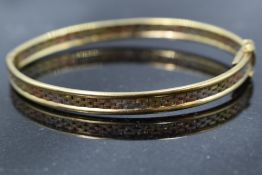 A modern 9ct gold triple coloured hinged bangle having brick effect decoration, approx 10.2g