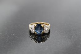 A sapphire and diamond ring, the oval sapphire approx 1ct being flanked by a trio of brilliant cut