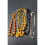 Five strings of beads including amber style, simulated pearl with gold clasp and jet style