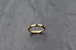 An 18ct gold emerald and diamond ring, having three emerald-cut emeralds interspersed by small