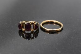 Two antique yellow metal rings, one having three oval amethyst stones in sealed mounts, size M and