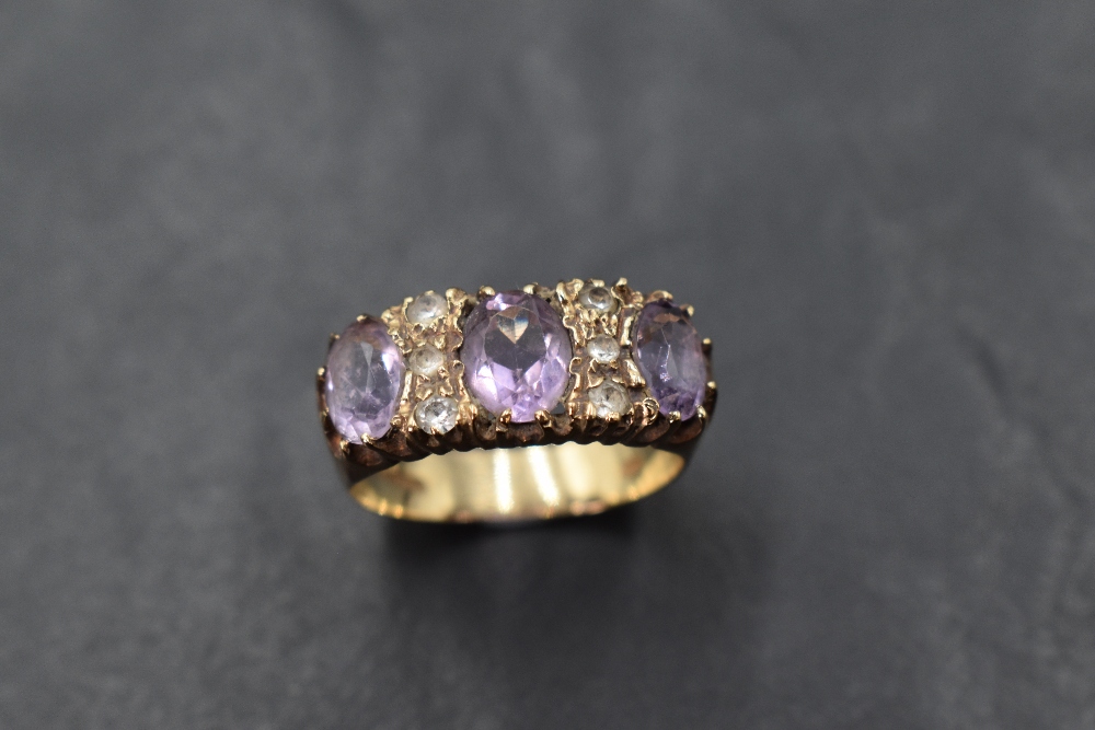 An amethyst trio ring interspersed by six cubic zirconia in a claw set panel mount on a 9ct gold - Image 3 of 3