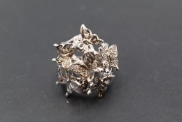 A silver butterfly cluster ring having diamond chip decoration to three of six butterflies to an