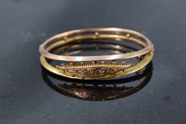 An early 20th Century 9ct gold double bar hinged bangle having engraved central panel, Chester 1913,