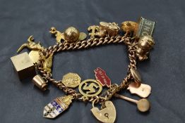A 9ct rose gold charm bracelet having padlock clasp and 22 yellow metal and 9ct gold charms