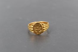 A Victorian 22ct gold ring, the circular platform with engraved crest, between fluted shoulders,