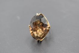 An oversized facett cut oval smoky quartz ring in a claw set basket mount on a 9ct gold loop, size O